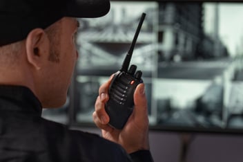 Security guard watching screens with camera recordings