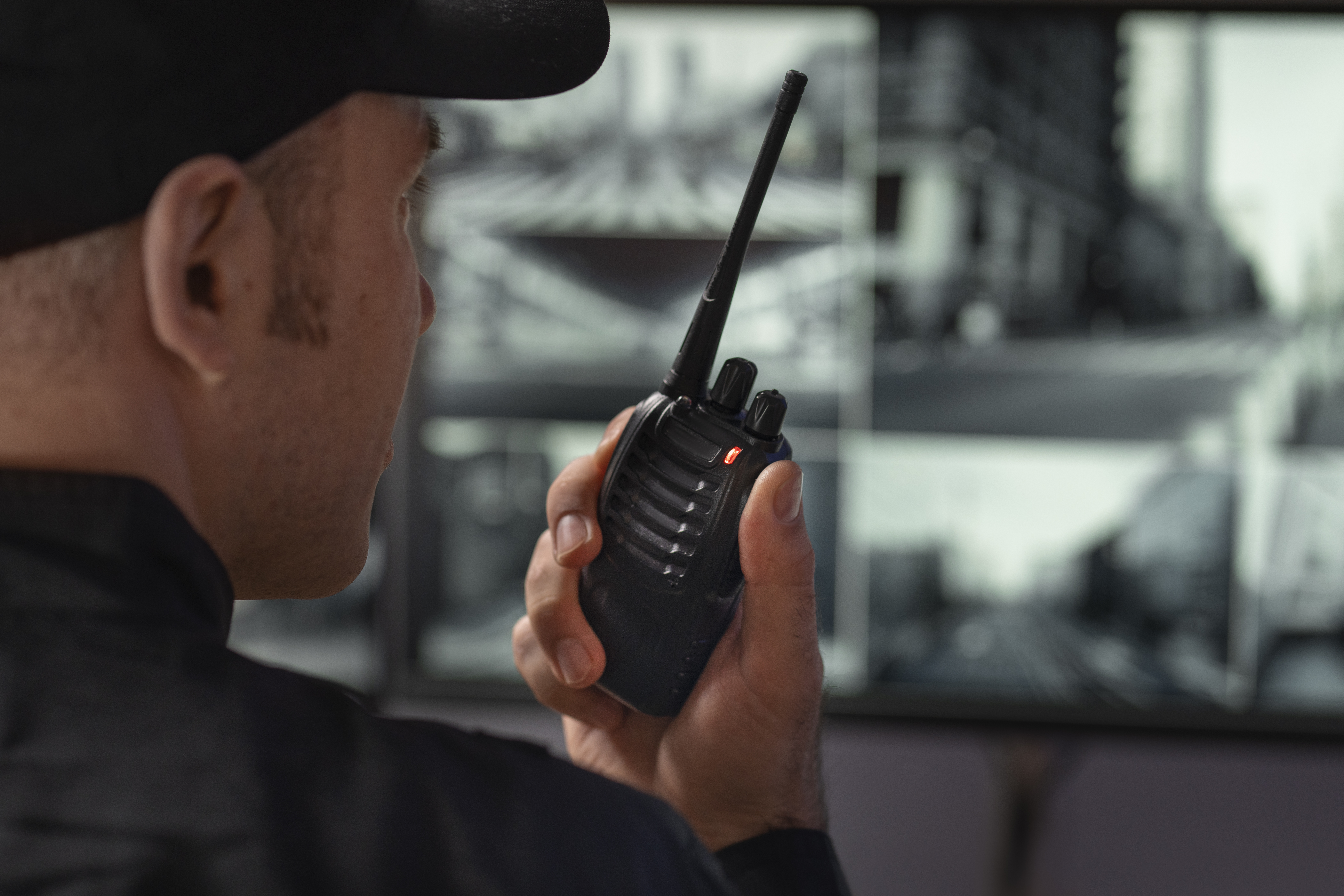 Security guard watching screens with camera recordings